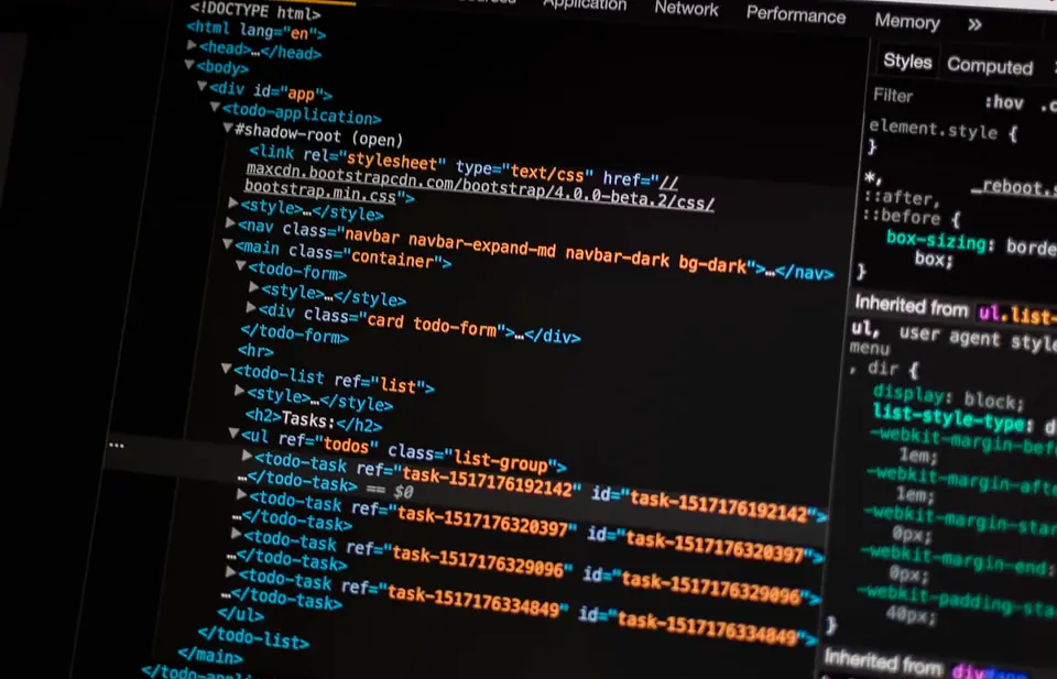 Monitor met code en laptop op een bureau, het dagelijkse werk van websiteonderhoud