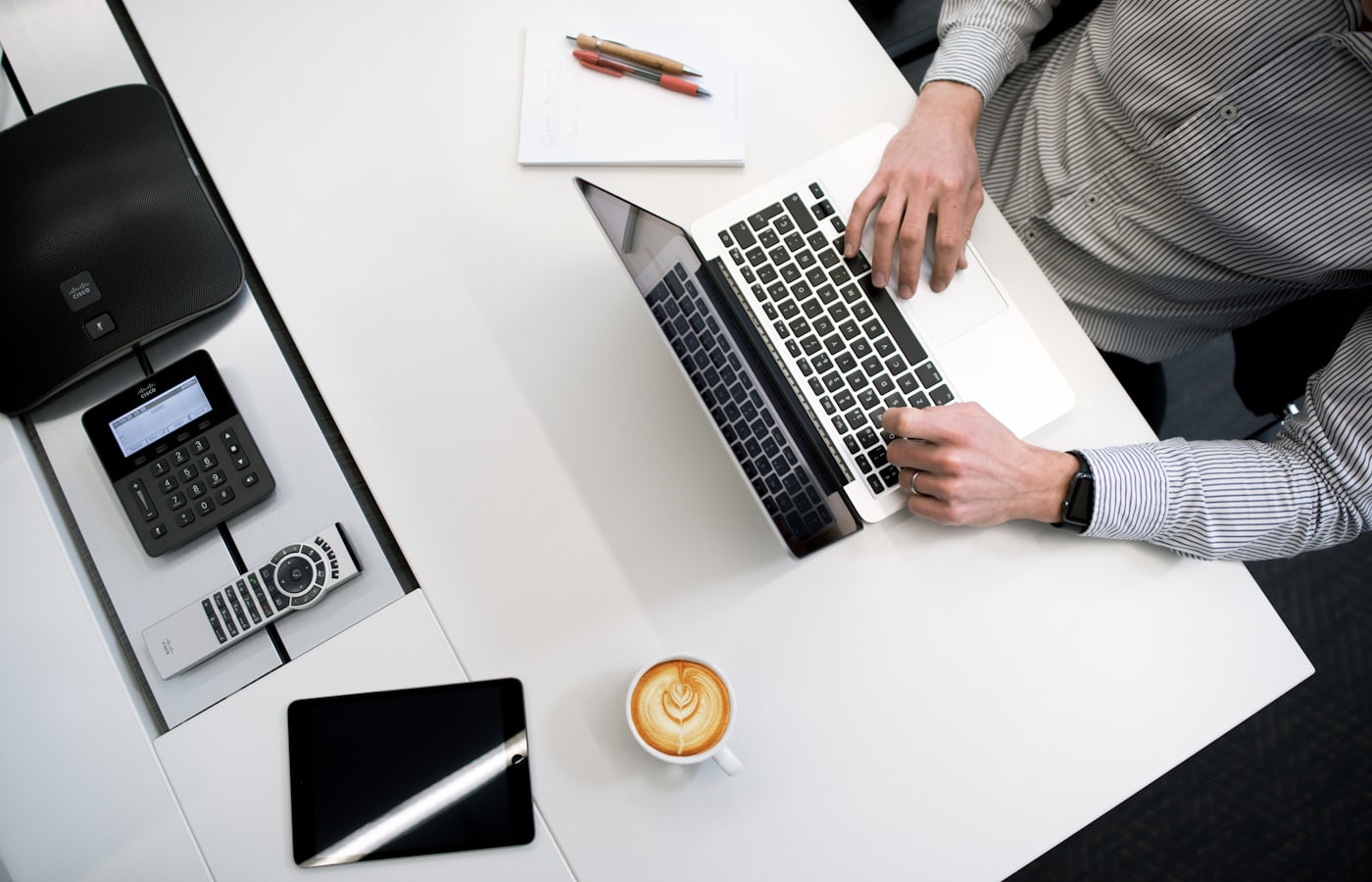 Laptop en koffie op een bureau van boven gezien, het controleren van een webshop-checkout
