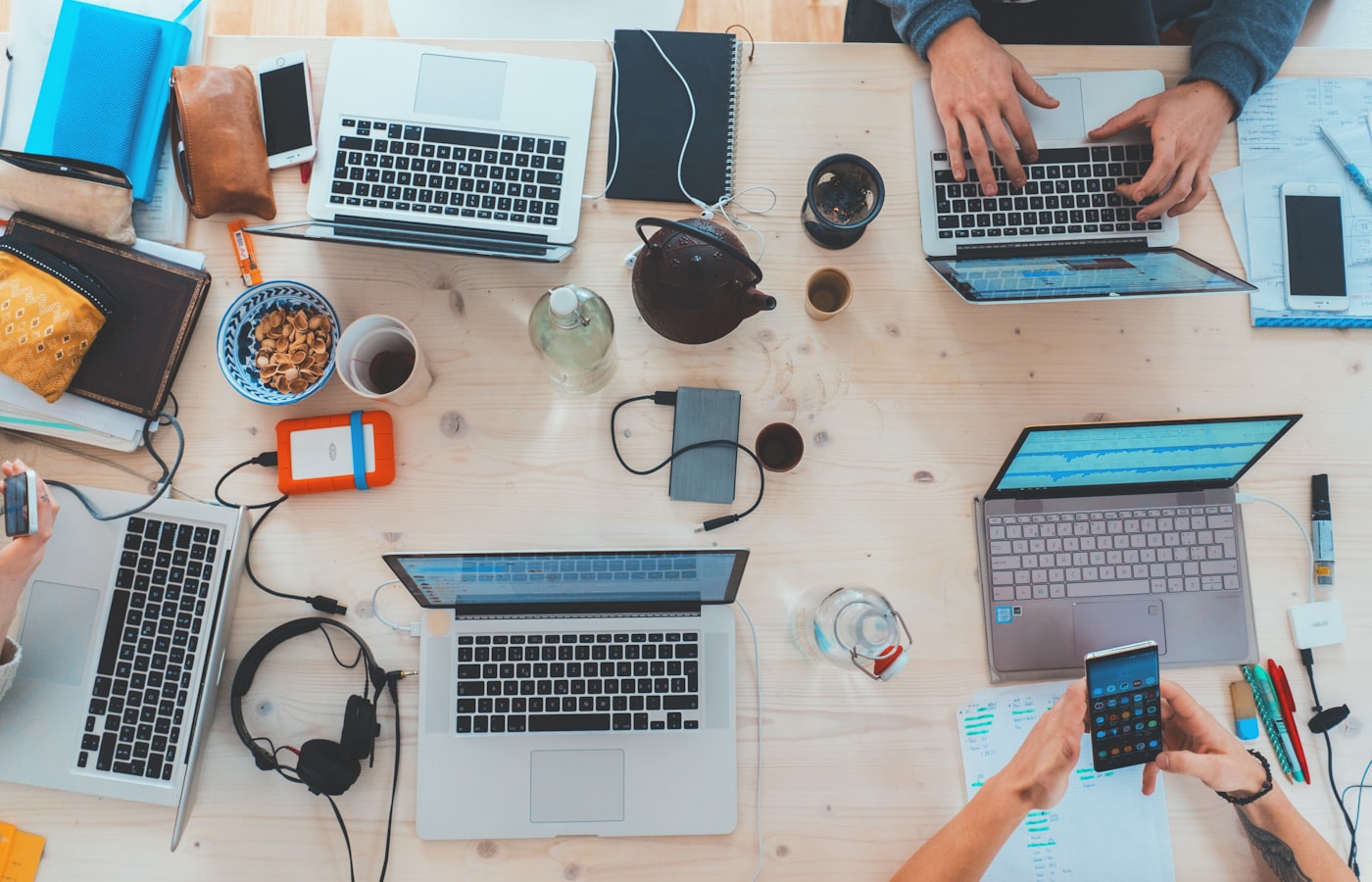 Team aan laptops van boven gezien, gezamenlijk beheer van meerdere websites